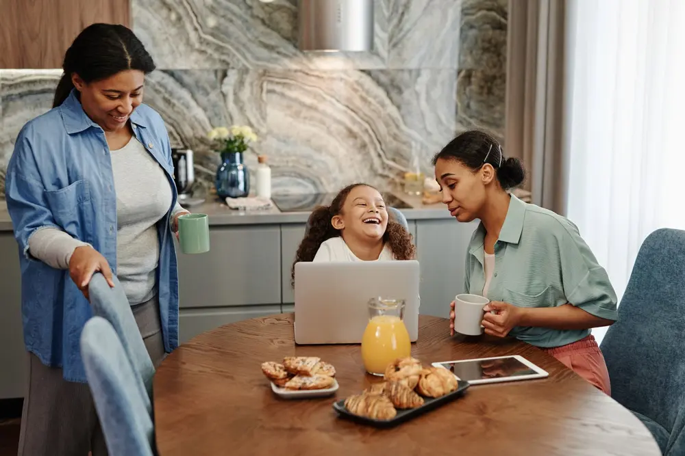 Familia compartiendo el desayuno en la mesa con tazas, como la familia de SubliVen en San Cristóbal